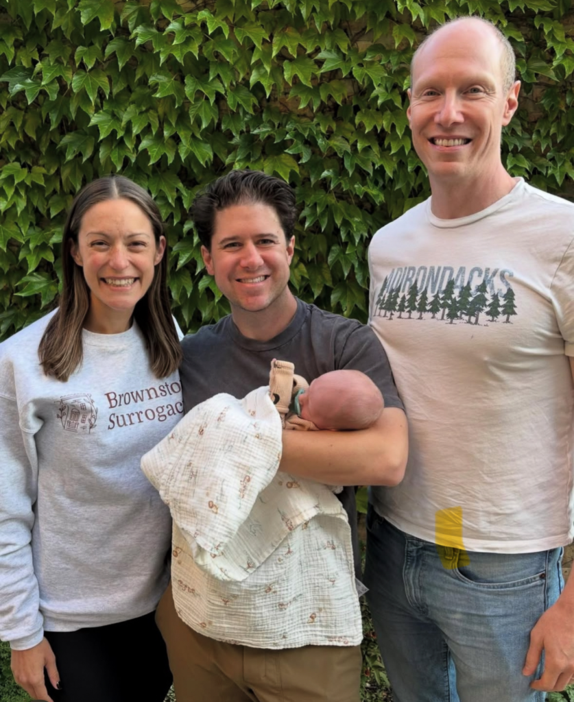 Surrogate Amanda pictured here with the intended parents she carried for holding the baby she delivered.